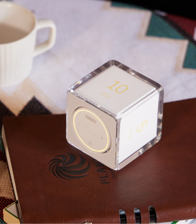 Settledy resting on a leather notebook beside a cup