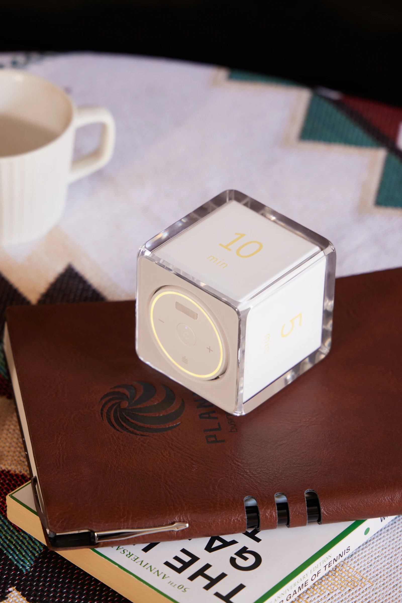Settledy timer resting on a leather notebook beside a cup