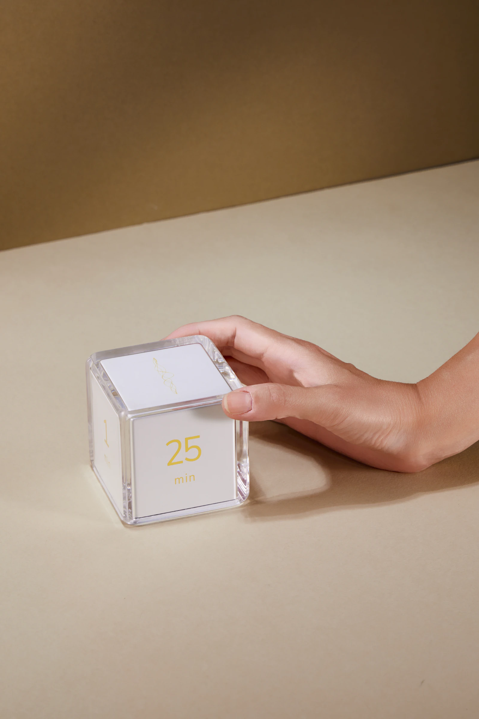 A hand gently turning the Settledy cube to the 25 minute face