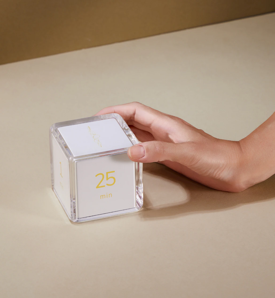 A hand gently turning the Settledy cube to the 25 minute face